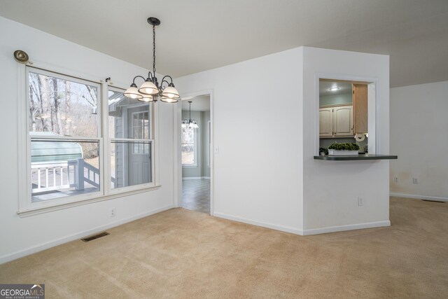 unfurnished dining area with visible vents, baseboards, a chandelier, and carpet flooring