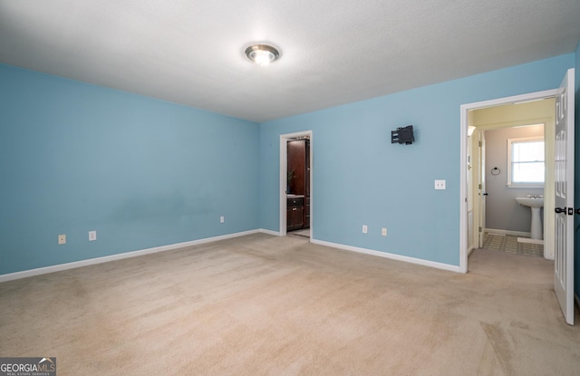 unfurnished bedroom with light carpet and baseboards