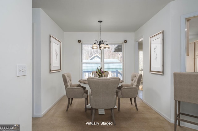 dining room featuring a notable chandelier, light colored carpet, and baseboards