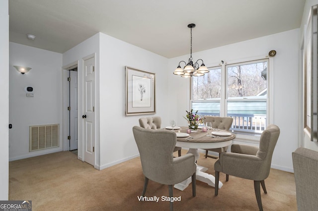 dining space with light carpet, visible vents, baseboards, and a notable chandelier