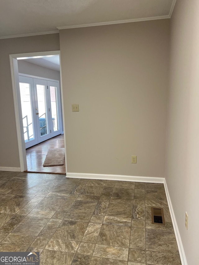 spare room with visible vents, baseboards, crown molding, and french doors