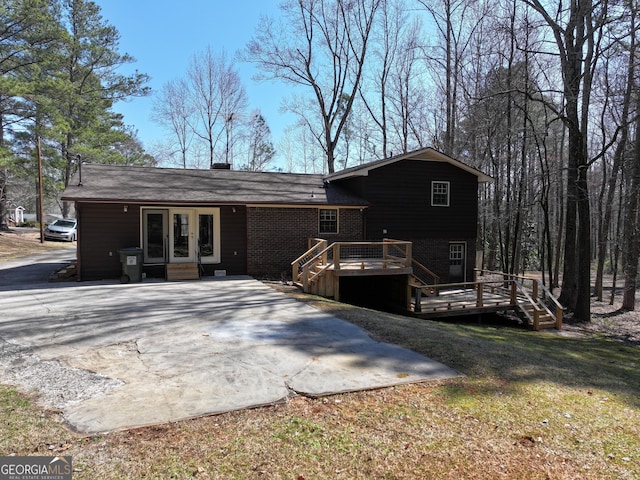 rear view of property featuring french doors and a wooden deck