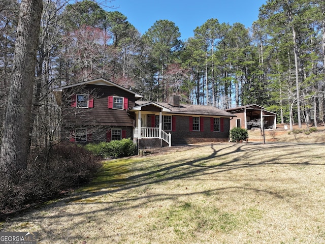 split level home featuring brick siding, a carport, a chimney, and a front lawn