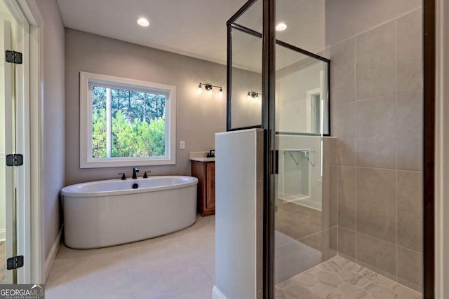 bathroom featuring vanity, recessed lighting, a freestanding bath, tile patterned flooring, and a shower stall