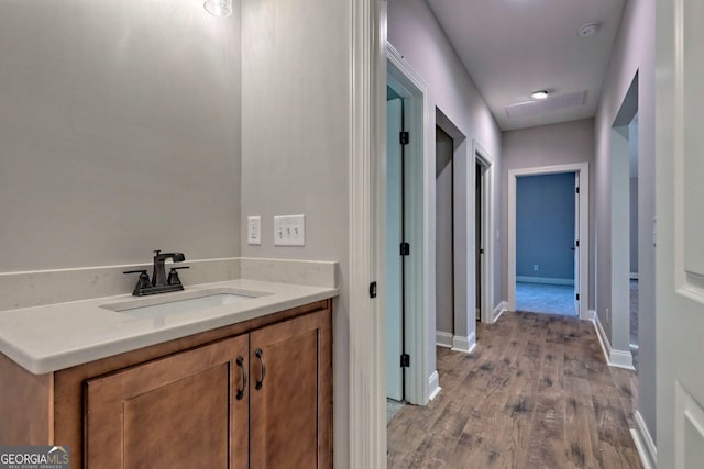 bathroom featuring vanity, wood finished floors, and baseboards