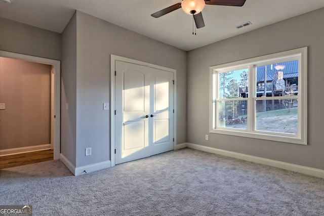 unfurnished bedroom with visible vents, baseboards, carpet, and a ceiling fan