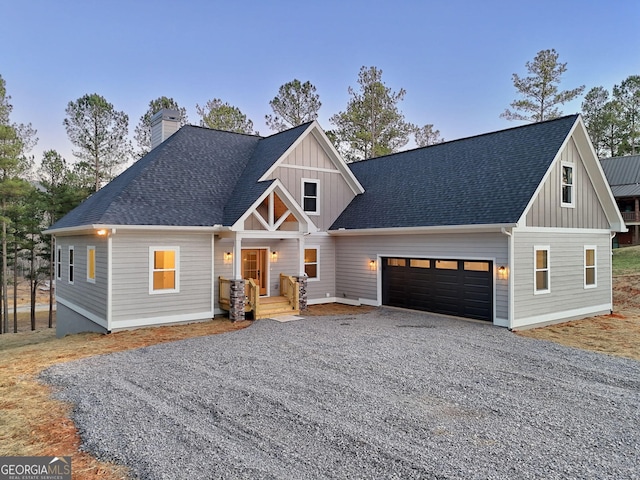 view of front of property featuring gravel driveway, a garage, board and batten siding, and a chimney