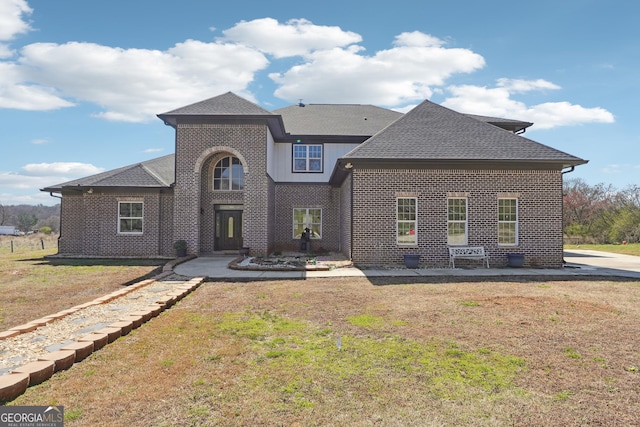 traditional home featuring a front lawn and brick siding