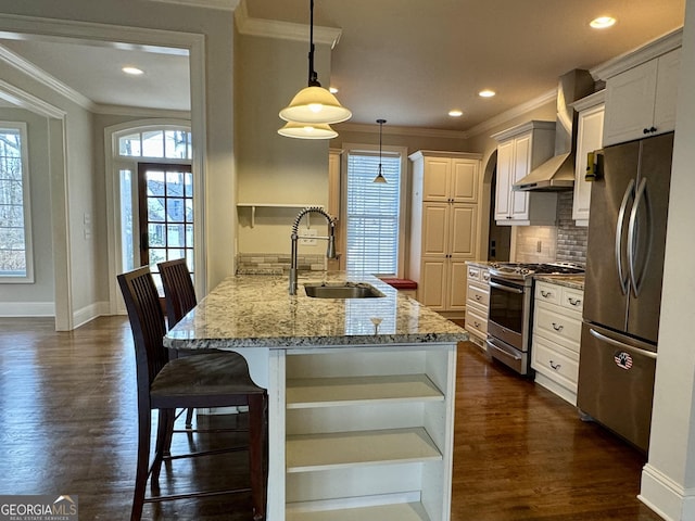 kitchen with ornamental molding, a sink, light stone counters, a peninsula, and appliances with stainless steel finishes