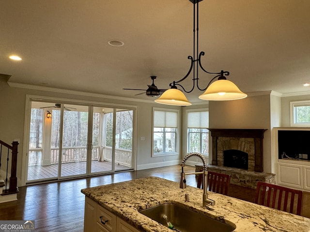kitchen with open floor plan, a ceiling fan, a sink, and crown molding