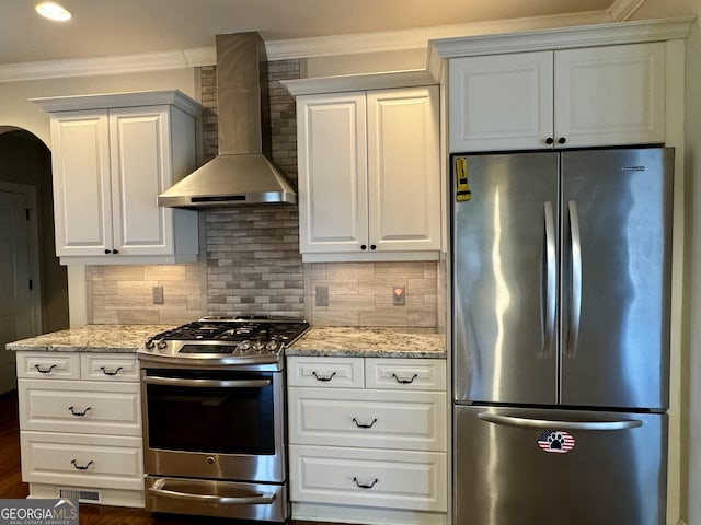 kitchen featuring crown molding, wall chimney exhaust hood, decorative backsplash, and stainless steel appliances