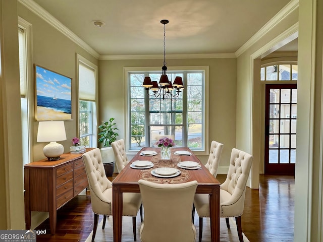 dining room with an inviting chandelier, ornamental molding, dark wood-type flooring, and baseboards