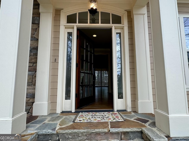 entrance to property featuring stone siding and a porch