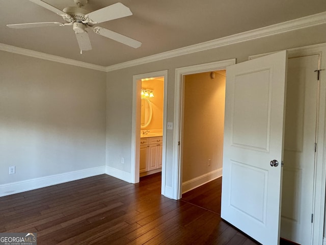 unfurnished bedroom featuring connected bathroom, crown molding, a ceiling fan, dark wood-style floors, and baseboards