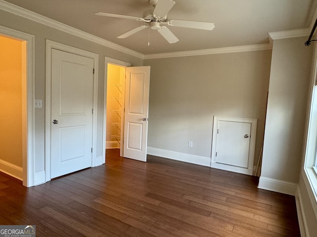 unfurnished bedroom featuring baseboards, dark wood-style flooring, a ceiling fan, and crown molding