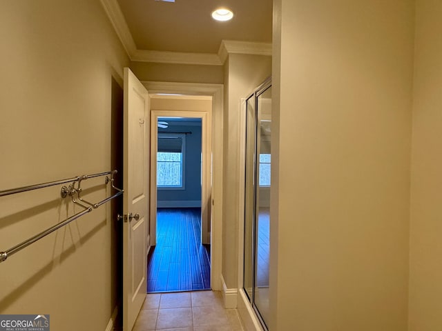 hallway featuring baseboards, crown molding, recessed lighting, and light tile patterned floors