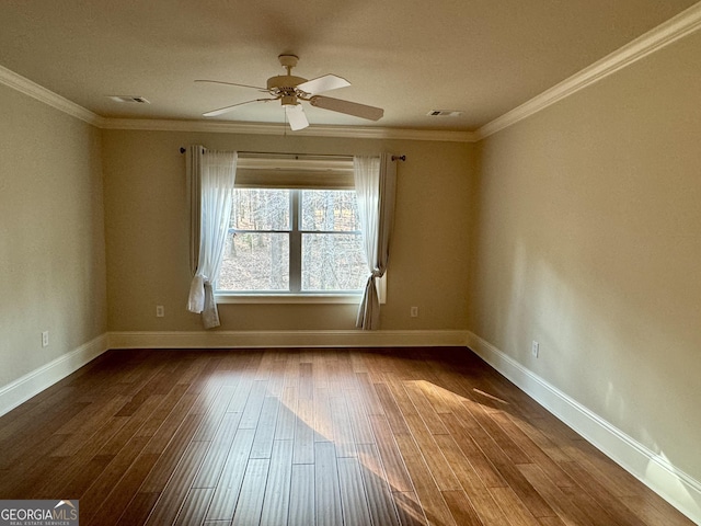 empty room featuring a ceiling fan, dark wood-style flooring, ornamental molding, and baseboards