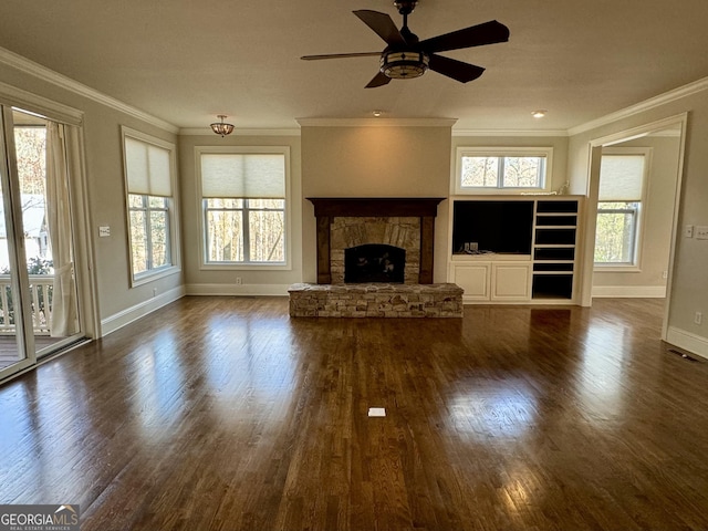 unfurnished living room featuring plenty of natural light, crown molding, and a fireplace