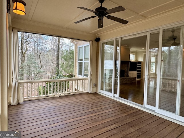 unfurnished sunroom with a ceiling fan and plenty of natural light