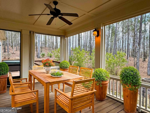 sunroom / solarium featuring a wealth of natural light, crown molding, a ceiling fan, and hardwood / wood-style flooring