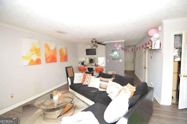 living area featuring baseboards, a ceiling fan, wood finished floors, and crown molding