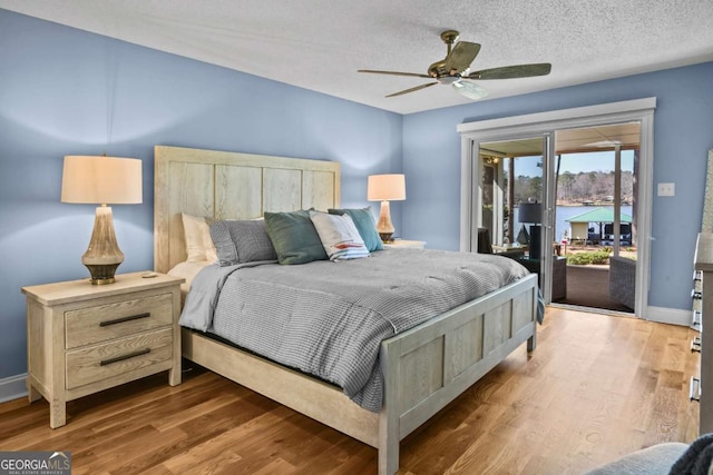 bedroom with wood finished floors, baseboards, ceiling fan, access to exterior, and a textured ceiling