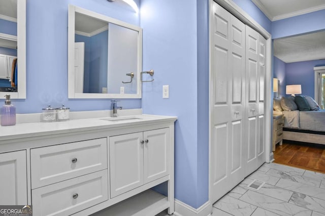 bathroom featuring vanity, marble finish floor, ornamental molding, and ensuite bathroom