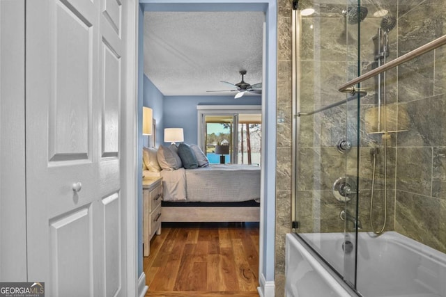 bathroom with wood finished floors, bath / shower combo with glass door, ceiling fan, ensuite bathroom, and a textured ceiling