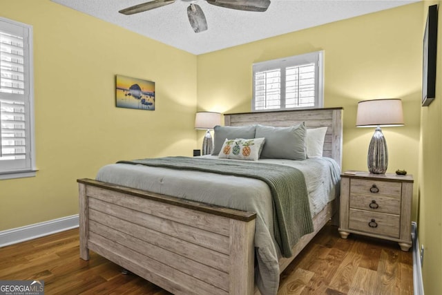 bedroom featuring baseboards, a textured ceiling, wood finished floors, and a ceiling fan