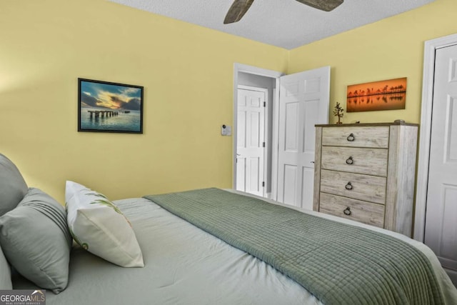 bedroom with a textured ceiling and a ceiling fan