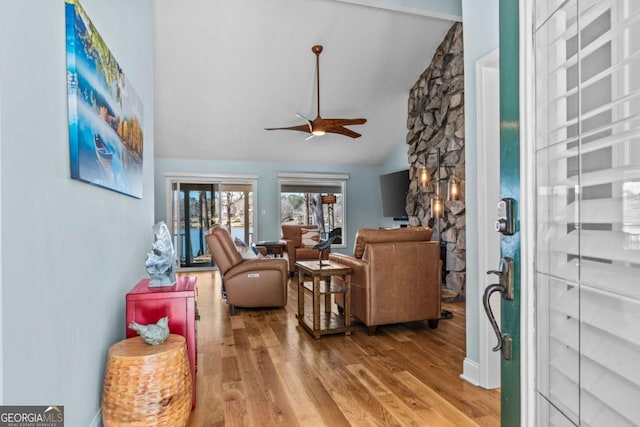 living room with lofted ceiling, a ceiling fan, and wood finished floors