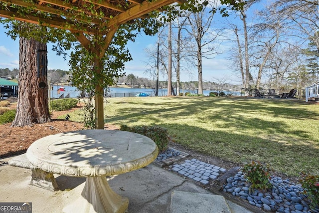 view of yard with fence, a patio, and a water view