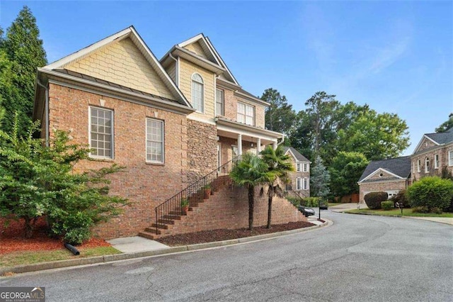 craftsman inspired home featuring brick siding and stairway