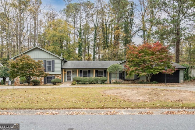 tri-level home featuring stone siding and a front lawn