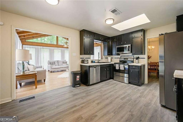 kitchen featuring light countertops, light wood-style floors, visible vents, and stainless steel appliances