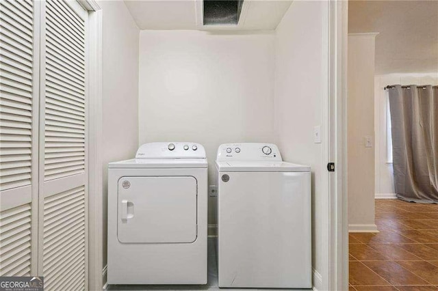 clothes washing area with dark tile patterned floors, laundry area, baseboards, and separate washer and dryer