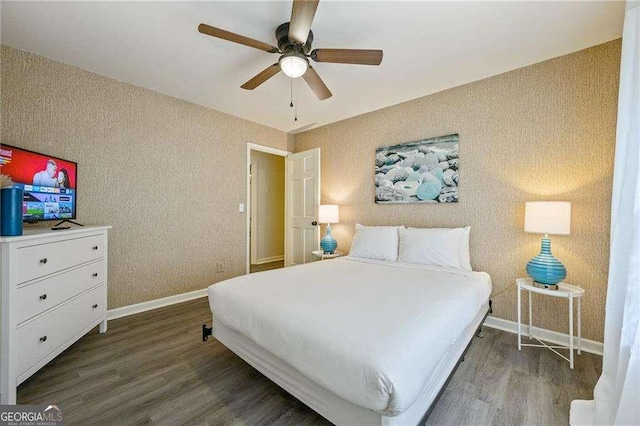 bedroom featuring ceiling fan, baseboards, wood finished floors, and wallpapered walls