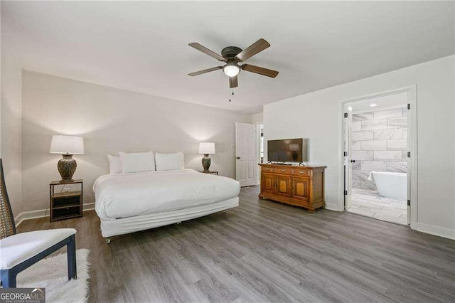 bedroom featuring ensuite bath, wood finished floors, and baseboards