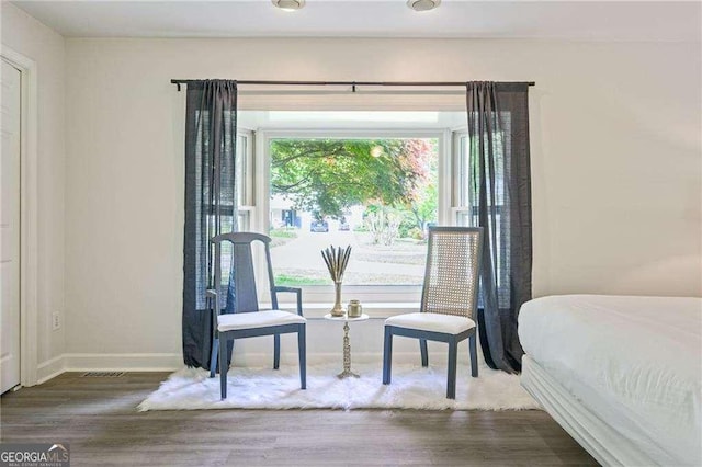 bedroom featuring visible vents, baseboards, and wood finished floors