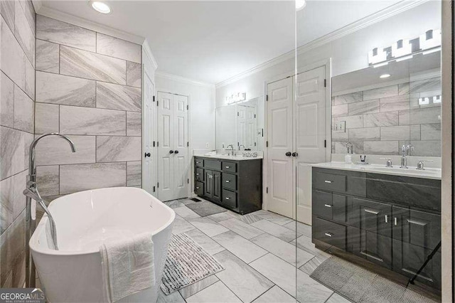 bathroom featuring a freestanding tub, marble finish floor, two vanities, ornamental molding, and tile walls