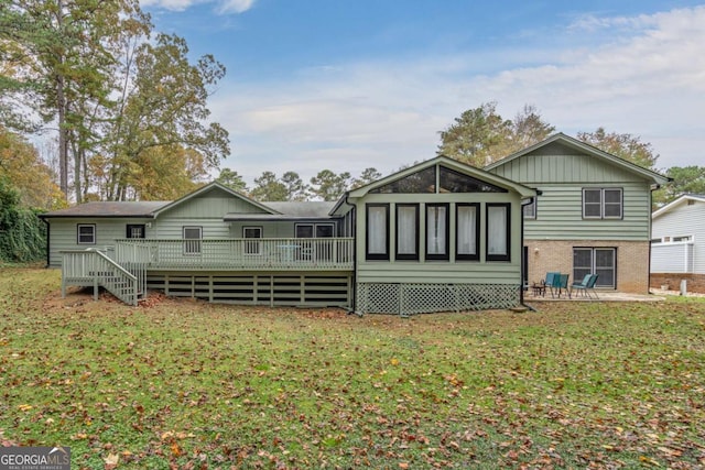 back of house with a wooden deck, a yard, and brick siding