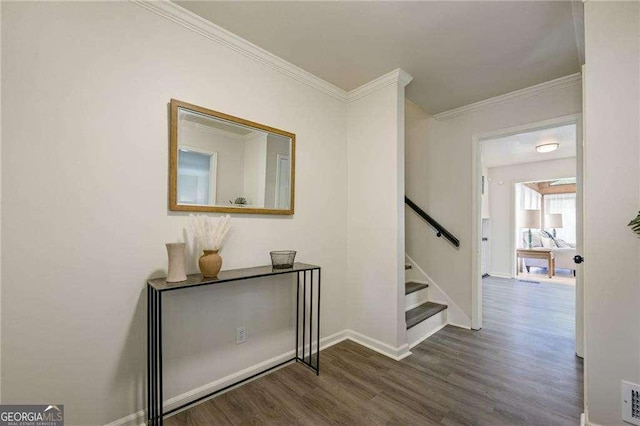 hallway featuring visible vents, crown molding, baseboards, stairs, and wood finished floors