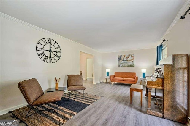 living room with a healthy amount of sunlight, crown molding, baseboards, and wood finished floors