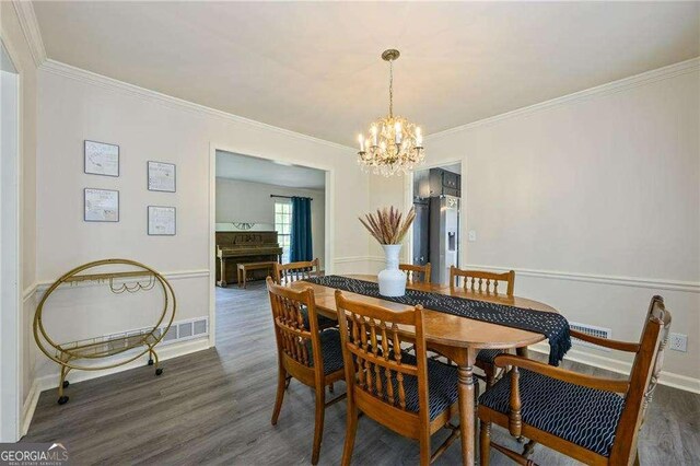 dining area with crown molding, a notable chandelier, wood finished floors, and baseboards