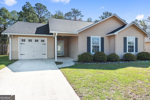 ranch-style house with an attached garage, a shingled roof, driveway, and a front lawn