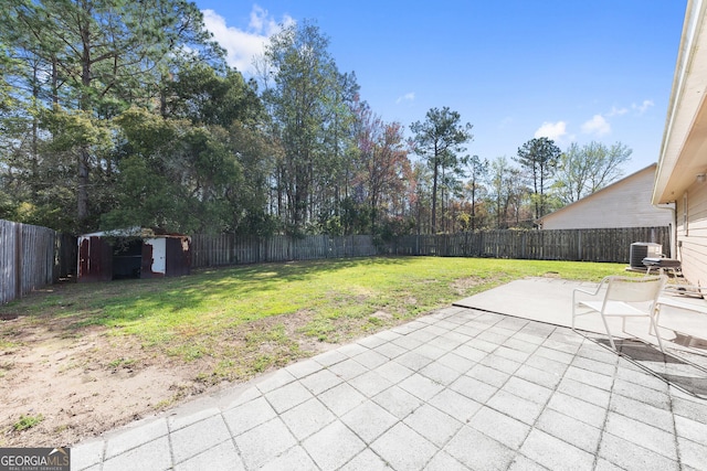 view of yard with a fenced backyard, central air condition unit, an outdoor structure, and a patio