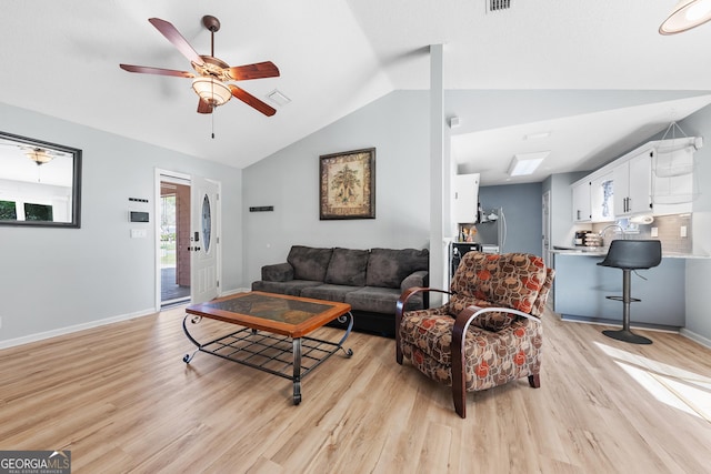 living area featuring visible vents, baseboards, light wood-style flooring, ceiling fan, and vaulted ceiling