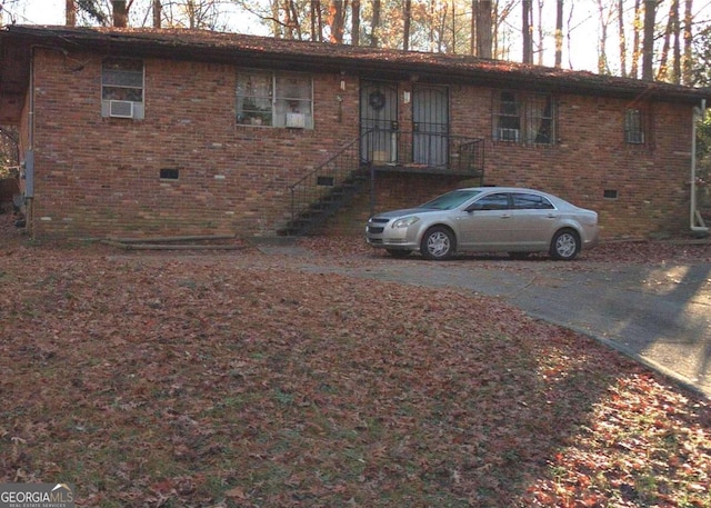 ranch-style home featuring brick siding, driveway, and crawl space