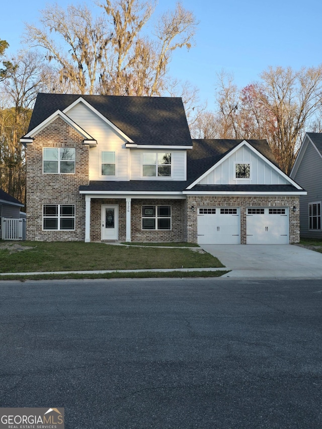 view of front facade with board and batten siding, concrete driveway, a front yard, a garage, and brick siding