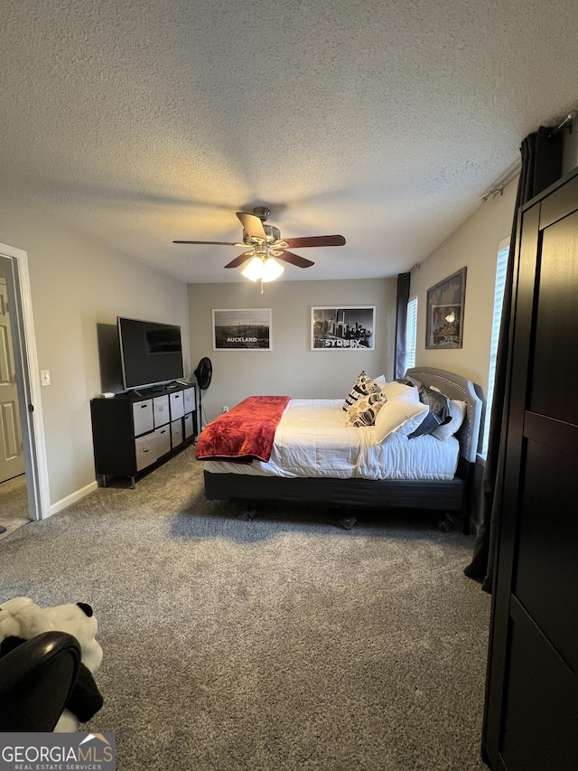 bedroom featuring baseboards, a ceiling fan, carpet flooring, and a textured ceiling